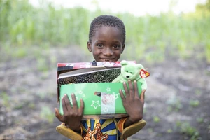 Child holding Operation Christmas Child box